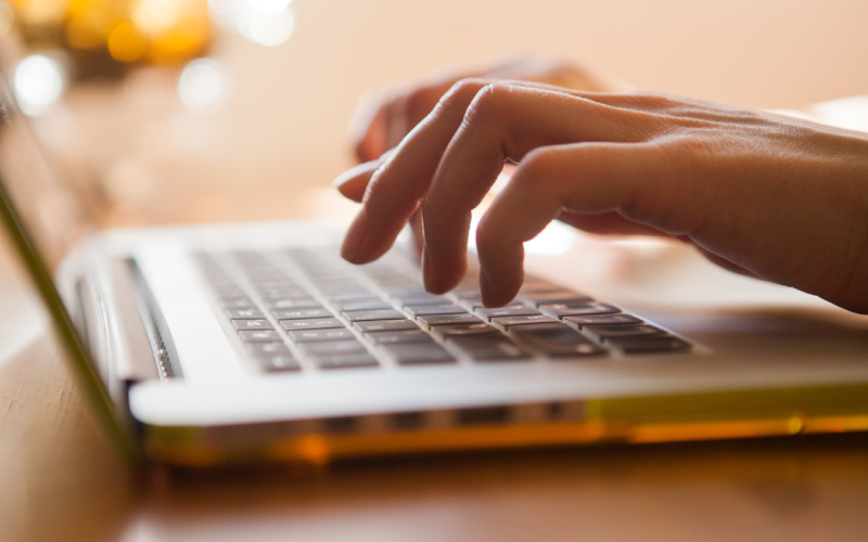 Here's an alt tag for the image: Hands typing on laptop keyboard.